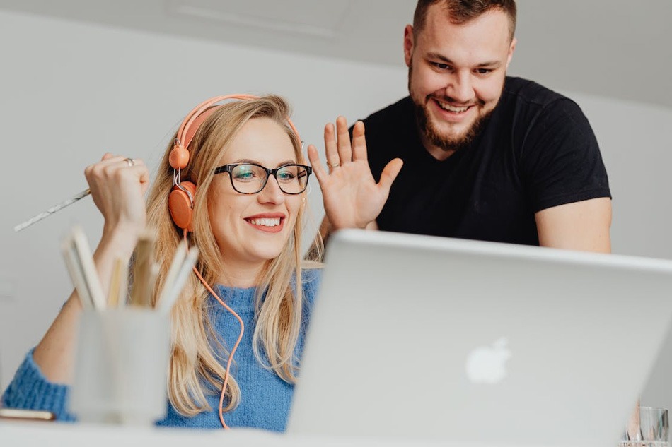 Why Smart Remote Workers Stop Buying New Laptops Two people waving during a video call.