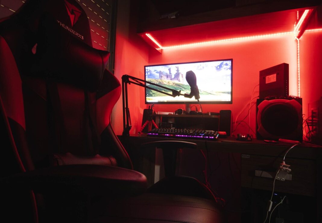 image Gaming setup featuring a microphone, neon lights, and a gaming chair.