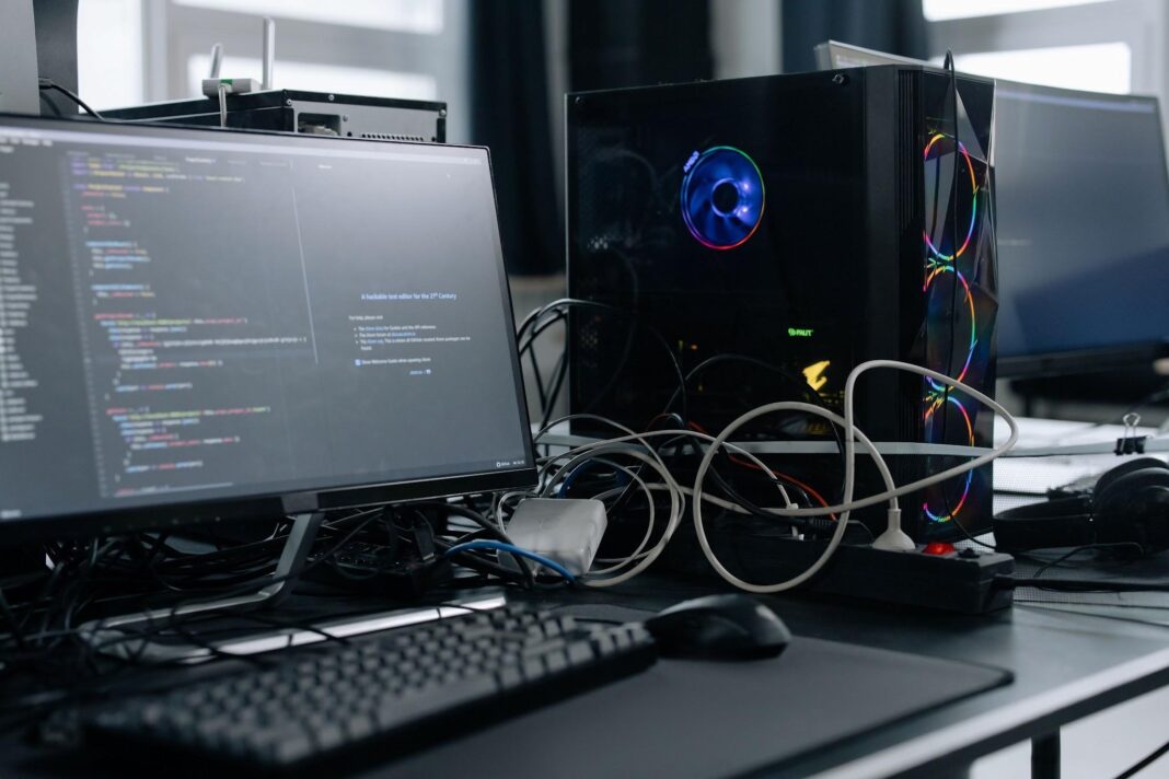 image Modern workspace with a computer, a PC tower, and peripherals.